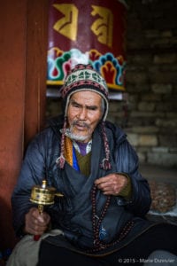 Old man with prayer wheel and beads