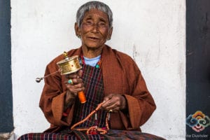 Old lady with a prayer wheel and beads